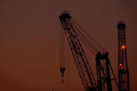 Industrial cranes at sunset