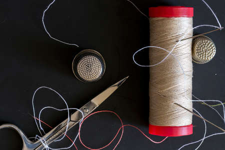 seamstress tools for sewing on a black background