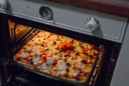 horizontal image of homemade pizzas while baking in the ovenの写真素材