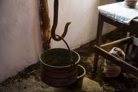 horizontal image with detail of an old copper pot hanging on a brazierの写真素材