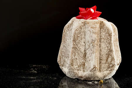 horizontal image with close detail of a typical italian Christmas cake, the pandoro with a black backgroundの写真素材