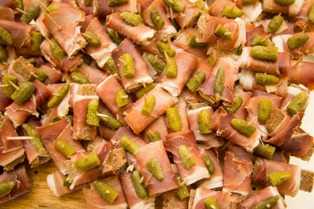 horizontal image with close-up detail of  ham morsels with gherkins and wholemeal bread, a typical antipasto of Italian cuisineの写真素材
