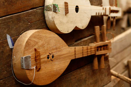 small hand crafted teak wood guitars being sold at a village market in Northern Thailand, Southeast Asiaの写真素材