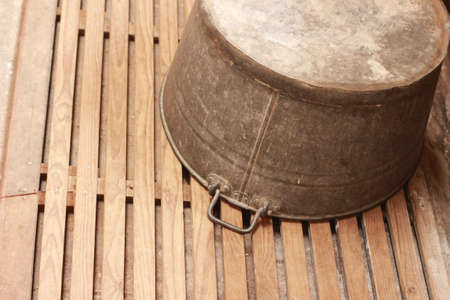 old vintage antique tin laundry tub sitting upside down on the wooden floor of an old laundry room in an old home, Victoria, Australiaの写真素材