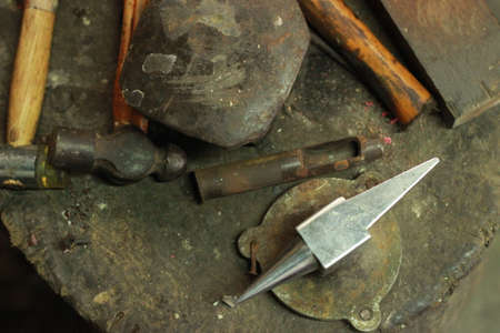 traditional worn and well used fine silversmiths tools on a craftsmans work bench in a work shop,...