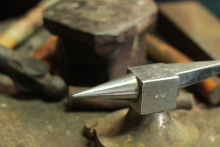 traditional worn and well used fine silversmiths tools on a craftsmans work bench in a work shop,...