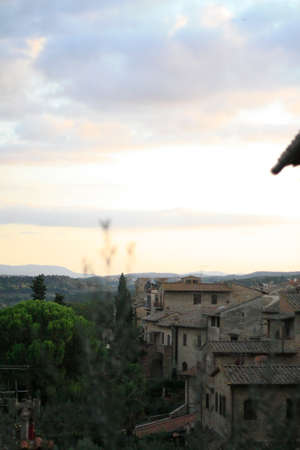 ancient Tuscan walled city houses with towers and stone walls and paved cobbled streets in Italyの写真素材
