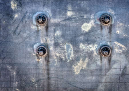 Four bolts on a corroded metal background.  Great as a background or for texture use.の写真素材