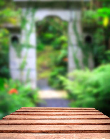 Old weather worn plank table top with tropical jungle gate in background   Focus is on planks in foregroundの写真素材