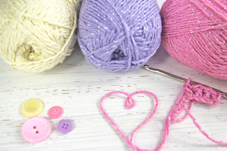 Crochet scene. Yarn Wool pastel colours with crochet hook heart and buttonsの写真素材