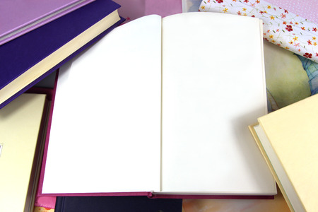 Blank pages in open book on background covered in books. Copy space.の写真素材
