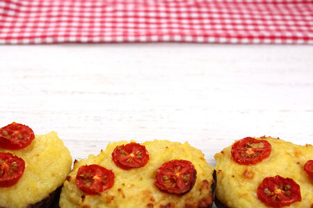 Twice baked potatoes on distressed wood white background with red gingham picnic cloth in background. Copy Space.の写真素材