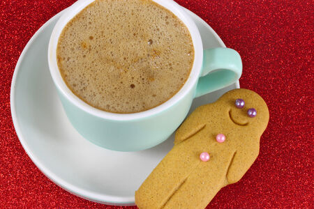Christmas Coffee and gingerbread man on red glitter background. Close up.の写真素材