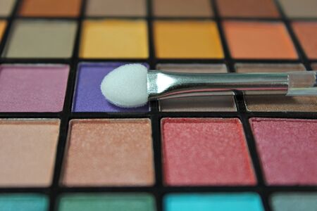 Close up colorful eyeshadow palette. Focus on the make up applicator.の写真素材