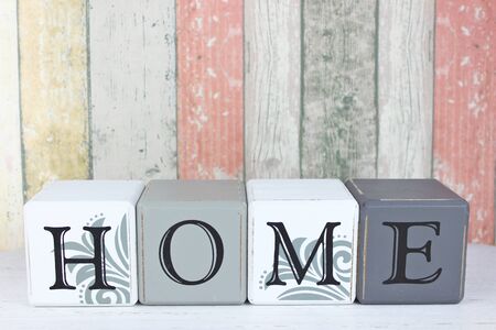 Blocks spelling the word 'Home' on a distressed wood background.の写真素材