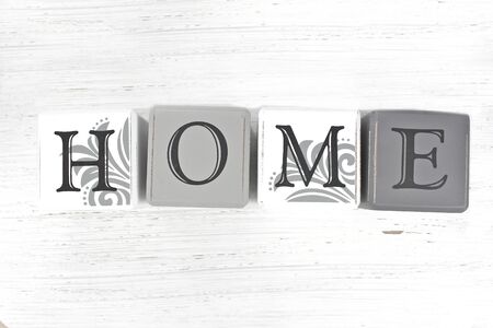 The word 'Home' spelled with blocks on a distressed wood background.の写真素材
