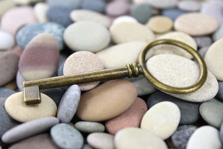 Old Brass lying key on a pebble beach. Macro.の写真素材
