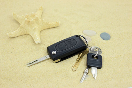 Keys on the sand with starfishの写真素材