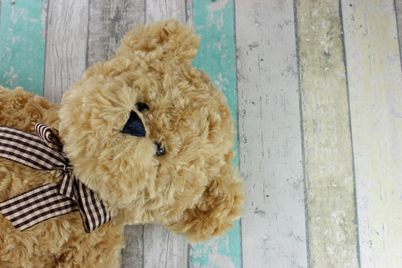 Cute Teddy bear on a distressed wood background.の写真素材