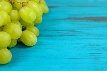 Close up of Bright green grapes on a turquoise distressed wooden backgroundの写真素材