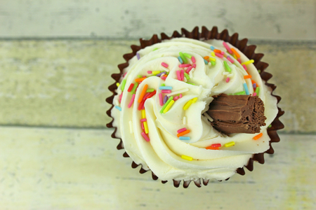 an Ice cream style cupcake on a rustic background.の写真素材