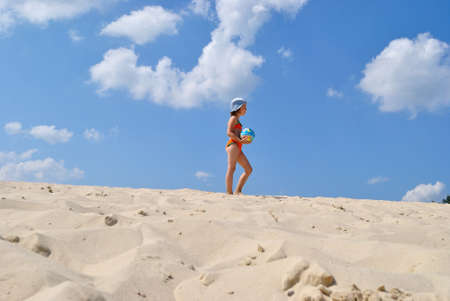 girl game of ball on sea song on background blue sky.の写真素材