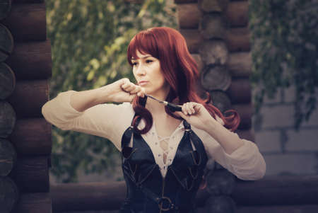 woman with red long hair robber lives in the forestの写真素材