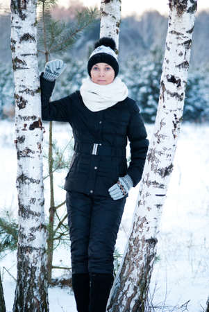 winter woman standing on the background of Russian birch in the snowの写真素材