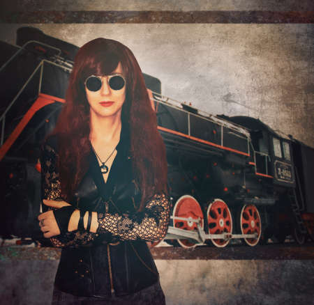 girl in the steampunk style stands on the background of the locomotiveの写真素材