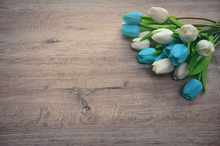 bouquet of multicolored tulips on a wooden background and with an empty place for an inscriptionの写真素材