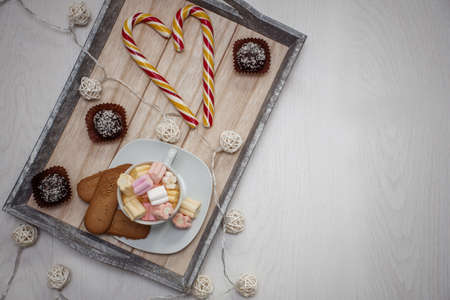 many different sweets on a tray and free space for an inscription on a wooden backgroundの写真素材