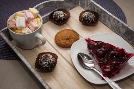 cake, biscuits and candies on a wooden trayの写真素材