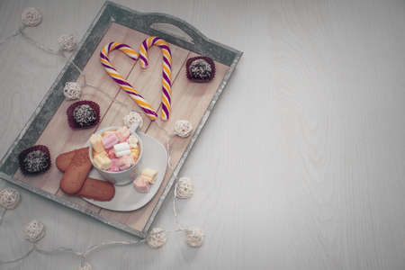 many different sweets on a tray and free space for an inscription on a wooden backgroundの写真素材
