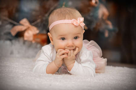 close-up baby girl lying under a christmas treeの写真素材