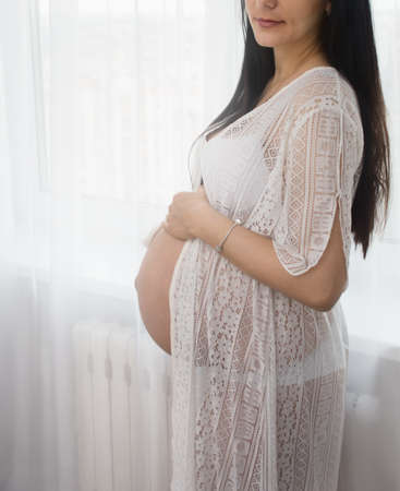 young brunette waiting for a baby in a white negligeeの写真素材