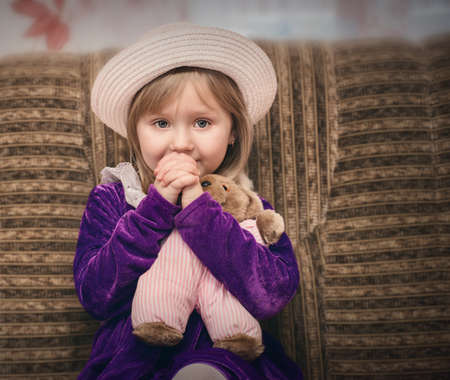 a child hugs a toy and watches cartoons worriesの写真素材