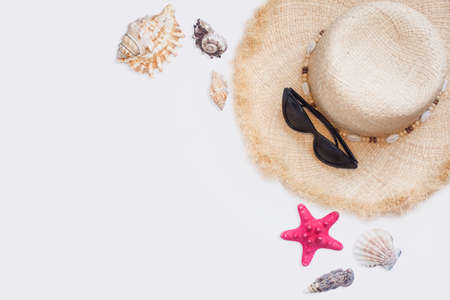 straw hat and shells and sunglasses isolated on white backgroundの写真素材