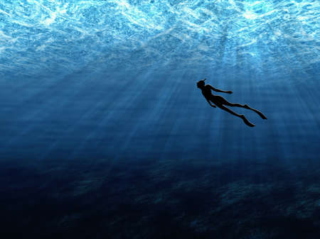 A diver swims peacefully underwater in the sea in the rays of lightの写真素材