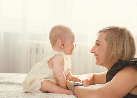 young mother with baby plays and laughsの写真素材