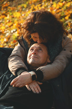 happy married couple over 50 years old, hugging in the fall on a warm sunny day, spending a day off together.の写真素材