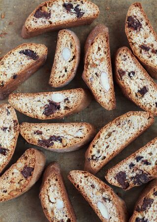 Handful of homemade biscotti with chocolate and almonds on a baking paper, rustic style, selective focus and room for textの写真素材