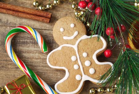 Homemade christmas painted gingerbreads gingerbread man and red present on the wooden background...