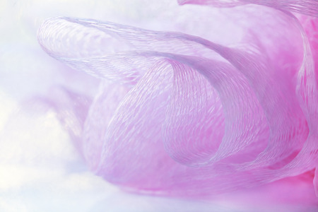 Soft pink bath puff or sponge, macro with copy space, selective focus