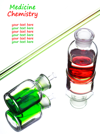 Chemistry laboratory glassware with green and red liquids in them on white background with place for textの写真素材