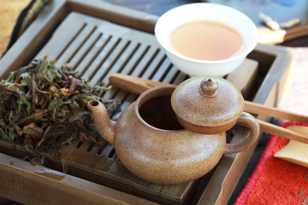 Traditional chinese tea ceremony accessories (tea pot and broken tea Feng Huang Puer tea) on the tea table, selective focusの写真素材