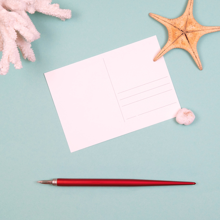 Womens traveler accessories: coral, starfish, postcard with copy space, pen on turquoise background. Summer background. Flat lay, overviewの写真素材