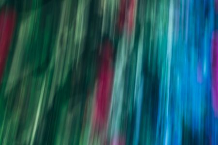 Defocused dynamic abstract background. Motion effect decorative backdrop. Natural summer blurry light and dark green pink texture. Fresh no focus plant leaves creative wallpaperの写真素材