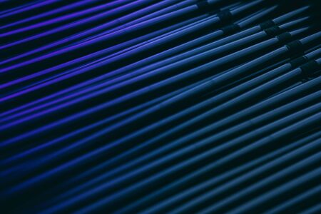 Stainless steel straws vertical abstract background. Metal pipes bundle side view decorative texture. Shiny metallic, aluminium hollow tubes in blue and violet colors backdrop for modern designの写真素材