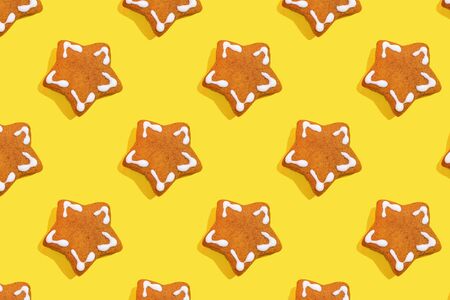 Many of cookies on yellow background. Gingerbread in shape of Christmas star. Many sweets cookie spattern. New Year Xmas and food conceptの写真素材