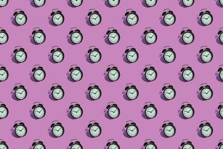Many black classic style alarm clock with hard shadow isolated on pink background. Smile time concept. Patternの写真素材
